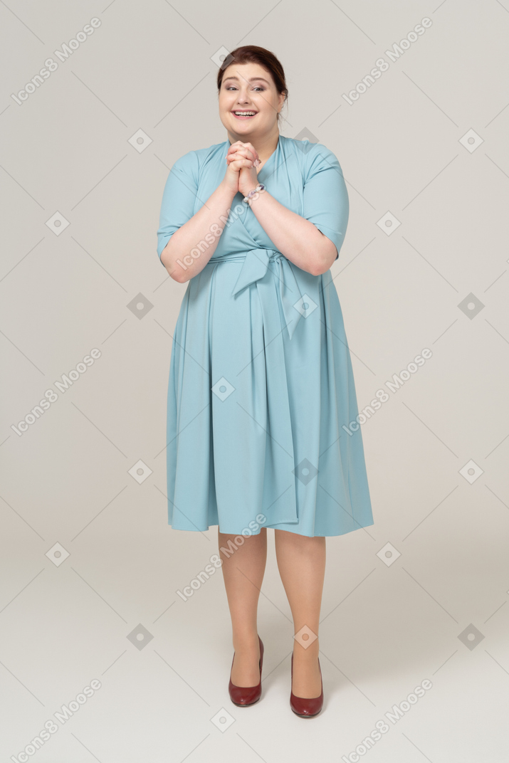 Mulher feliz de vestido azul olhando para a câmera