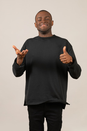 Young smiling man showing thumbs up