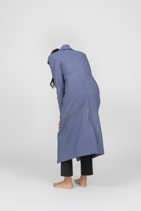 Back view of a hunched over person in coat