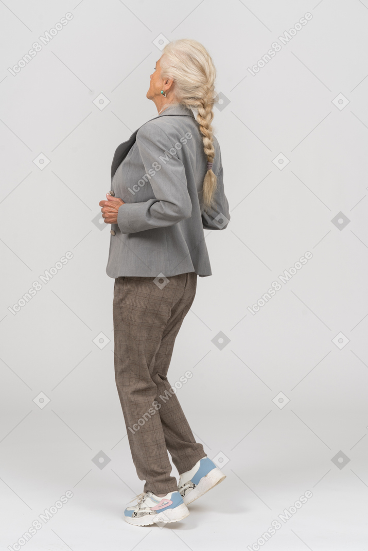 一位身穿灰色西装跑步的老妇人的侧视图