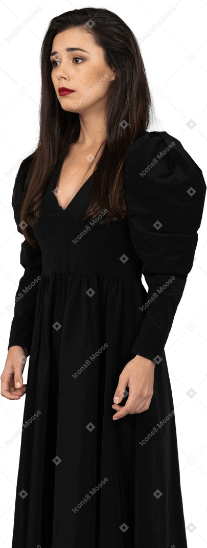 静止している黒いドレスを着た若い女性の4分の3のビュー