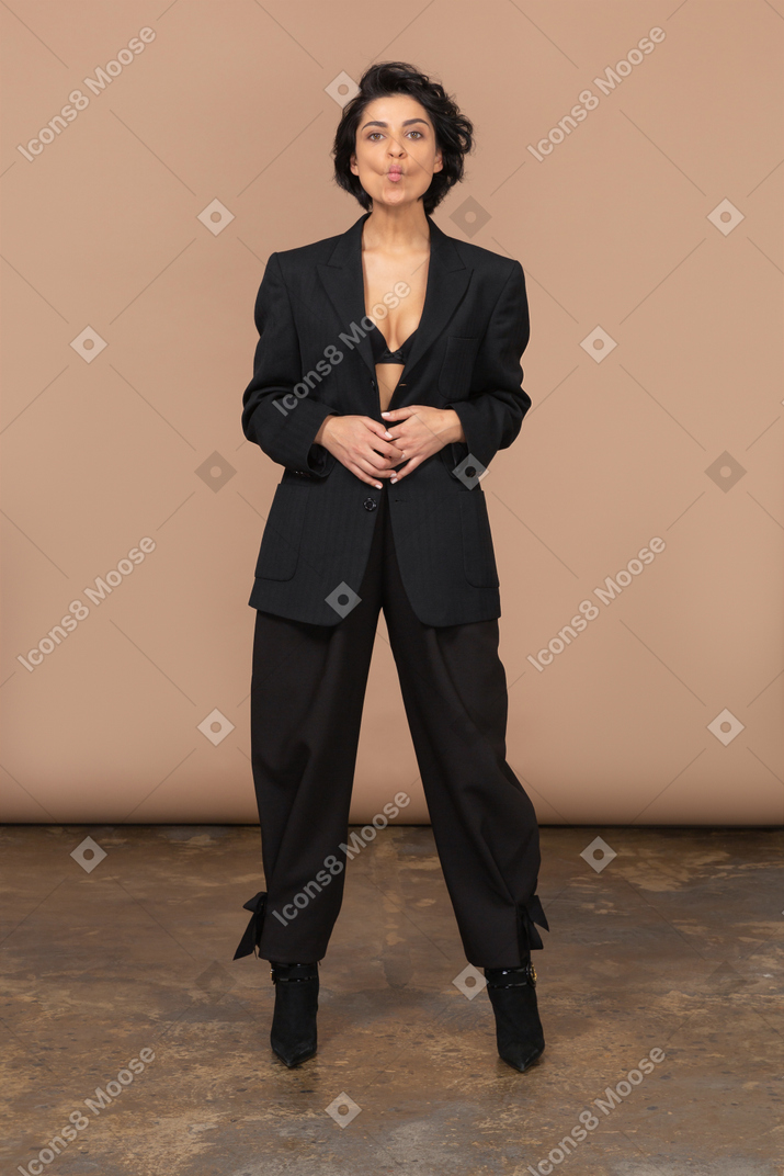 Front view of a businesswoman in a black suit putting hands on stomach and pouting