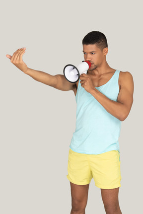 A man in shorts speaking into a megaphone