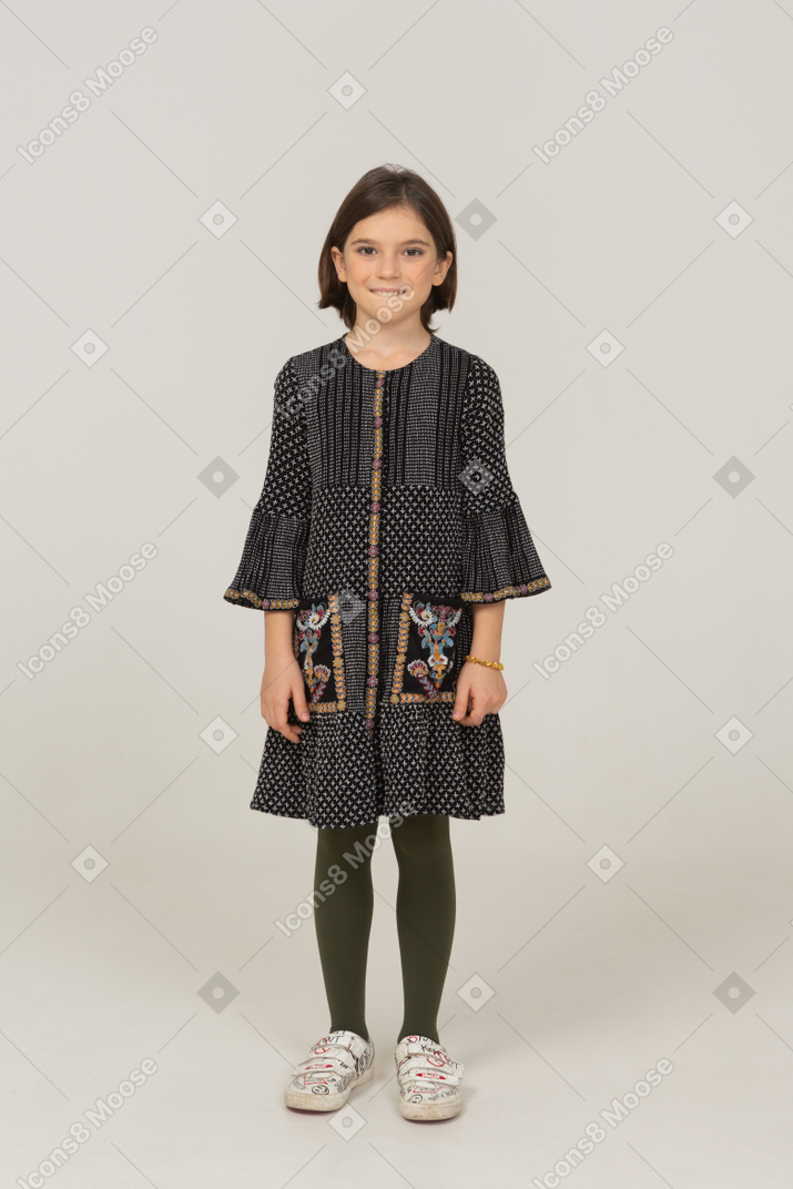 Front view of a nervous little girl in dress biting lips