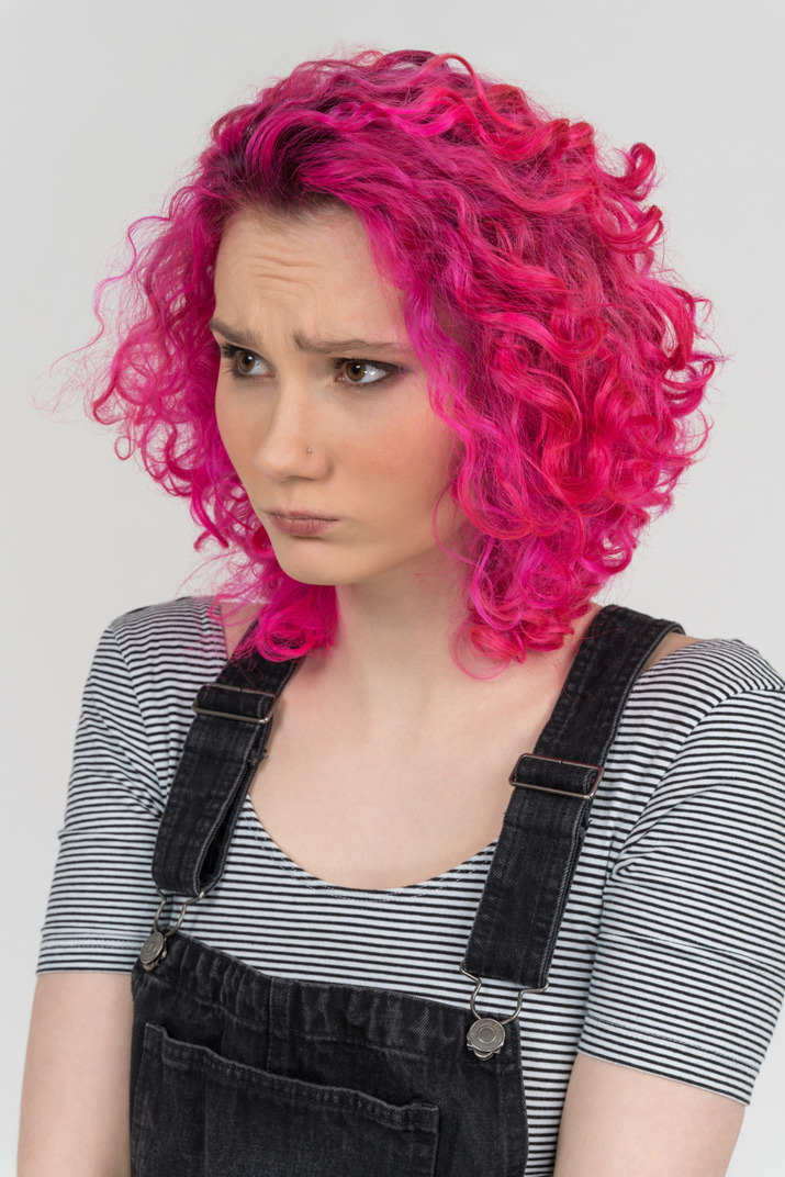 Portrait of a frown caucasian girl with pink hair