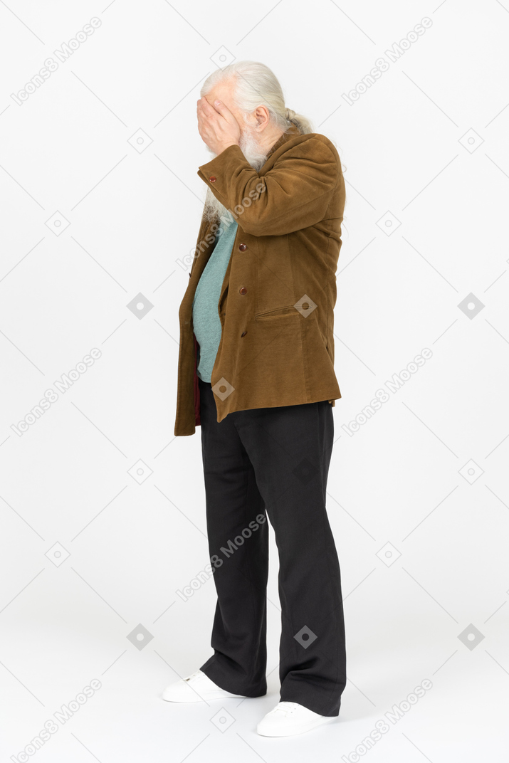 Portrait of an old man covering his face