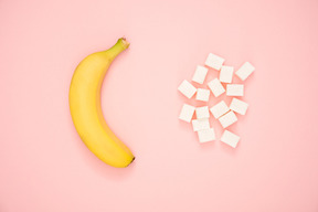 Banana and sugar cubes over contrast background