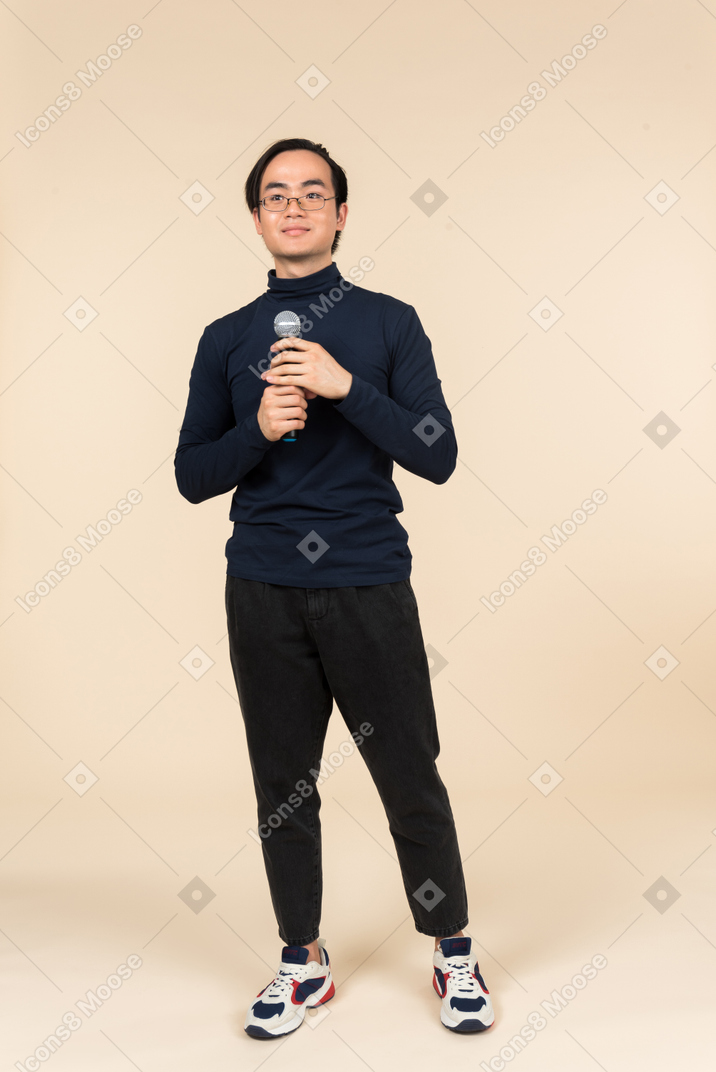 Young asian man speaking into a microphone