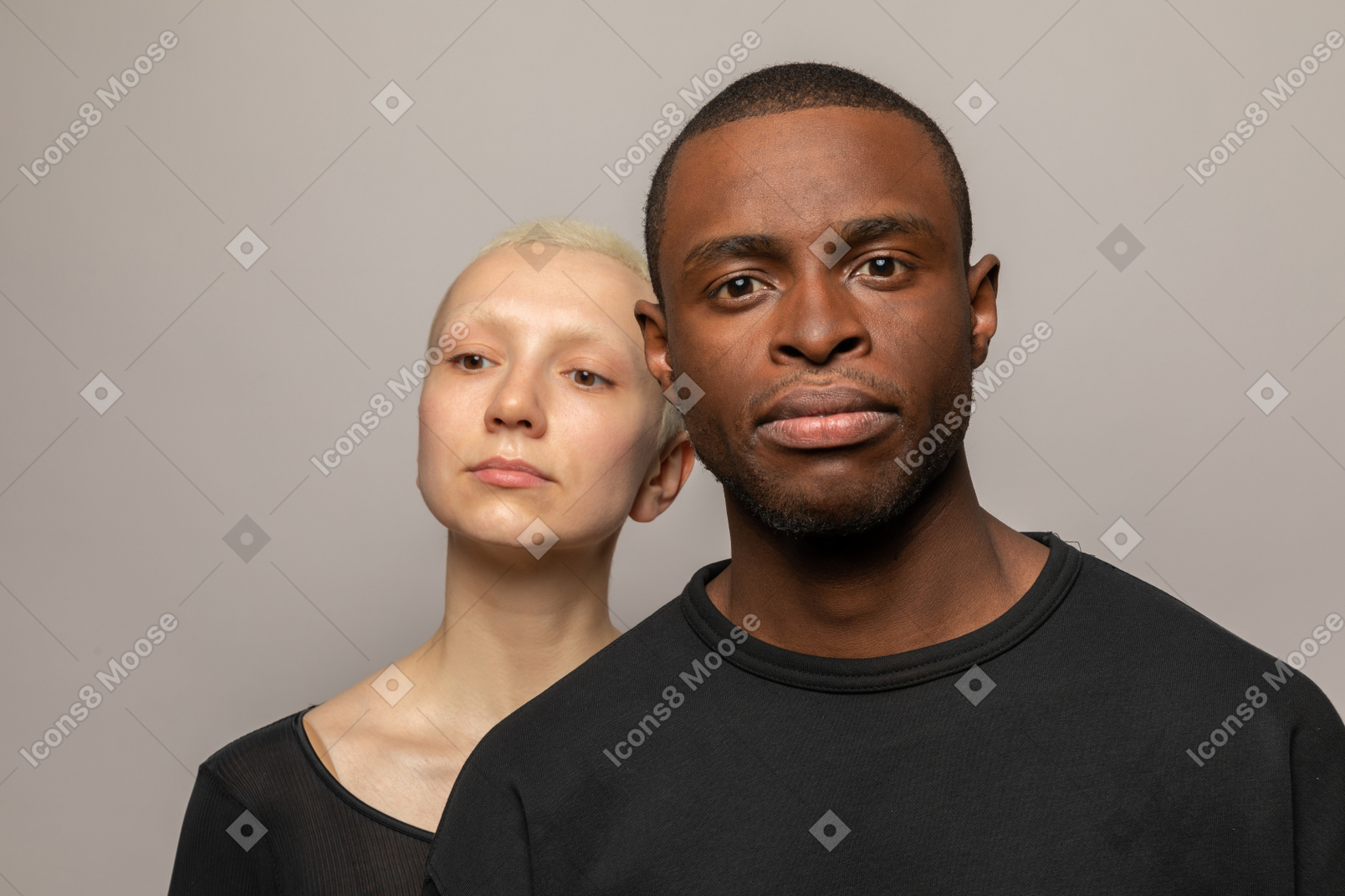 Young man in front woman looking at camera