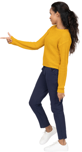 Side view of a girl in casual clothes pointing with finger