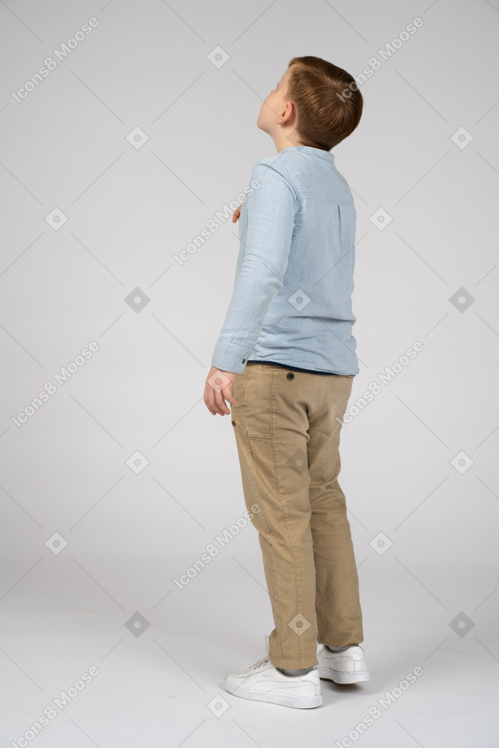 Boy in casual clothes looking up