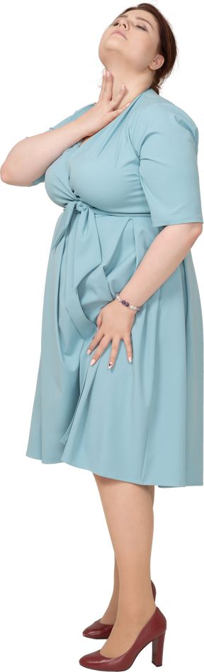 Женщина в синем платье позирует в профиль