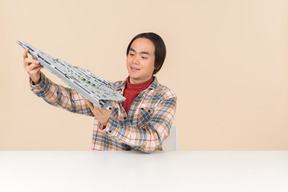Um cara geek asiático em uma camisa quadriculada