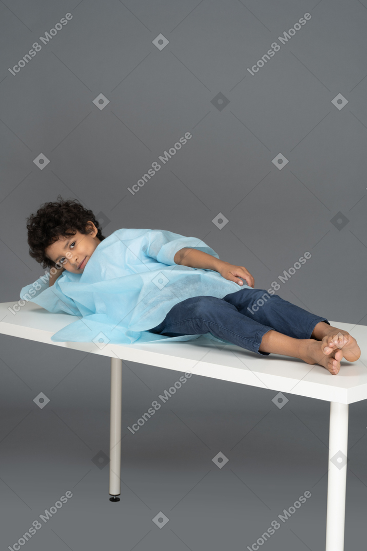 Niño sonriente acostado en la mesa