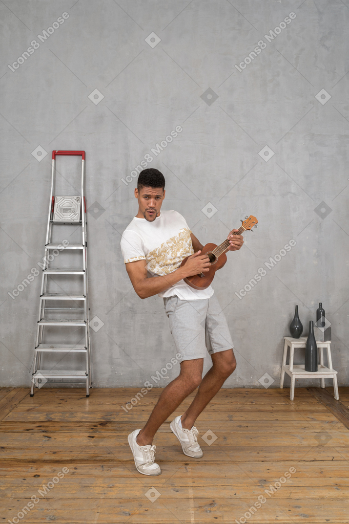 Three-quarter view of a man stricking a rock pose with ukulele