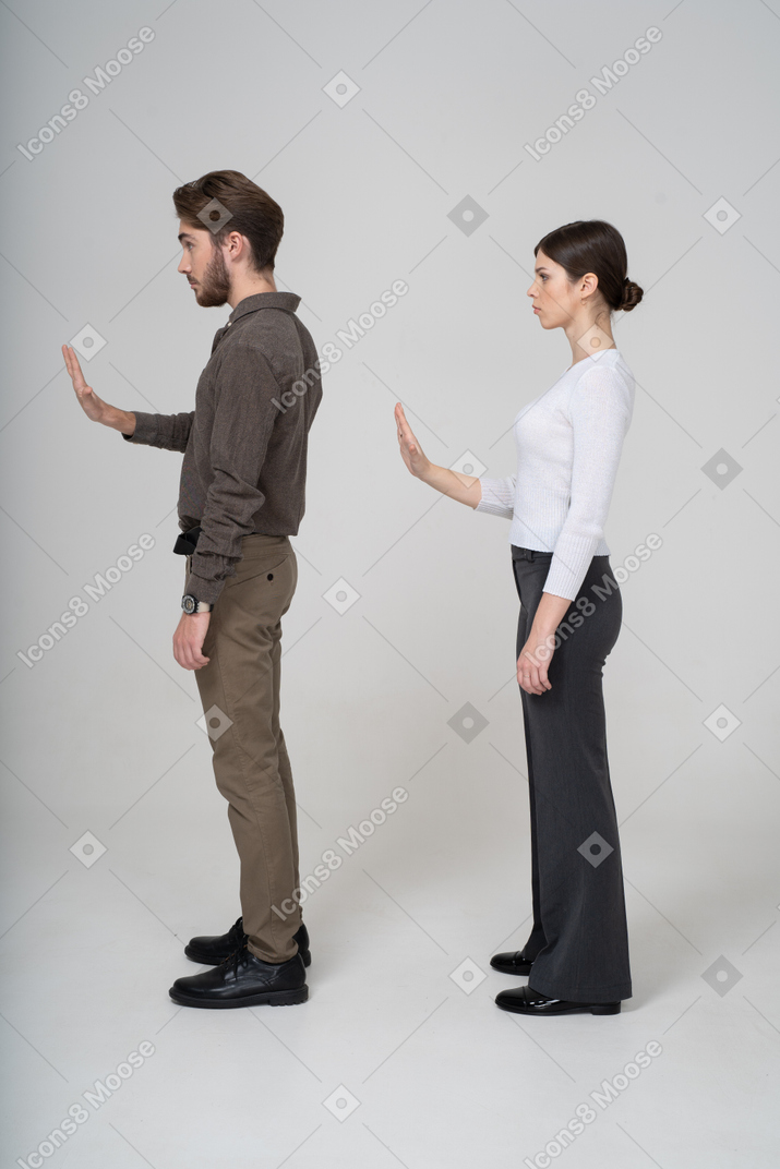 一对年轻夫妇在办公室服装伸出手中的侧视图