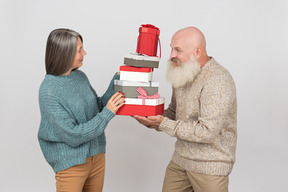 Aged man giving gifts to an elegant mature woman