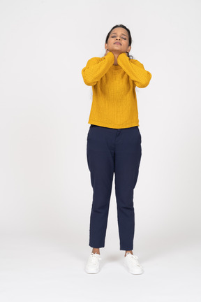 Vista frontal de uma garota com roupas casuais, posando com as mãos no pescoço