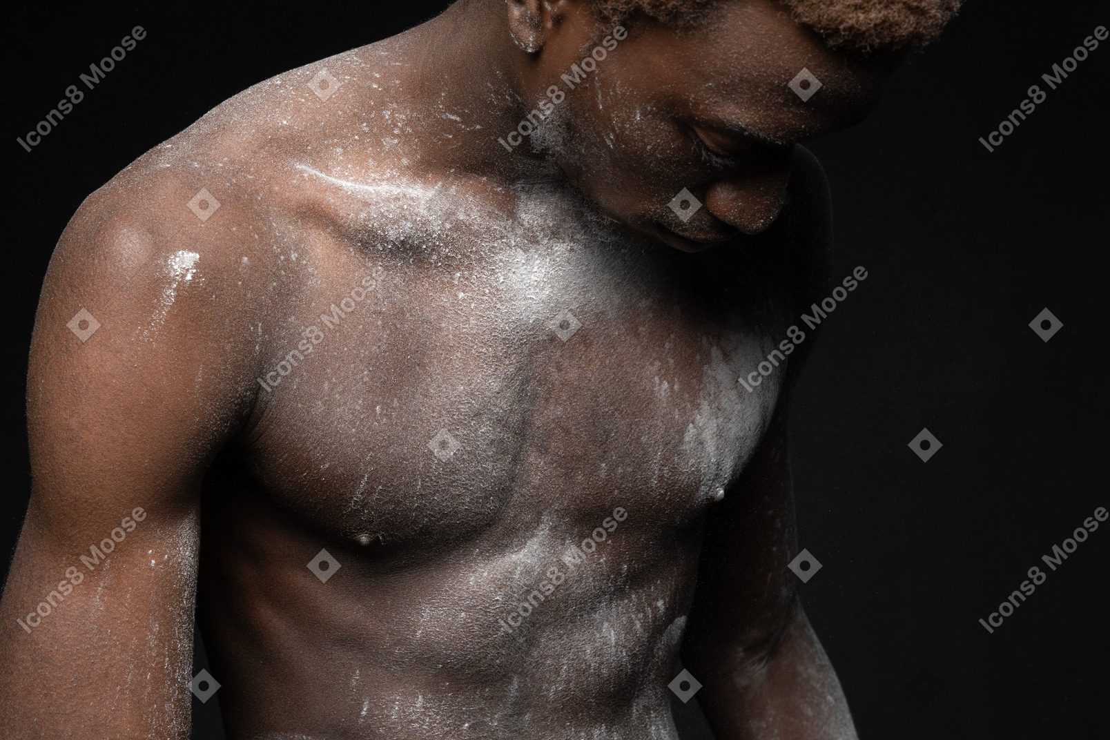 Sensual shot of a young male with his torso covered with flour