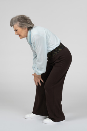 Old woman touching her sore knee