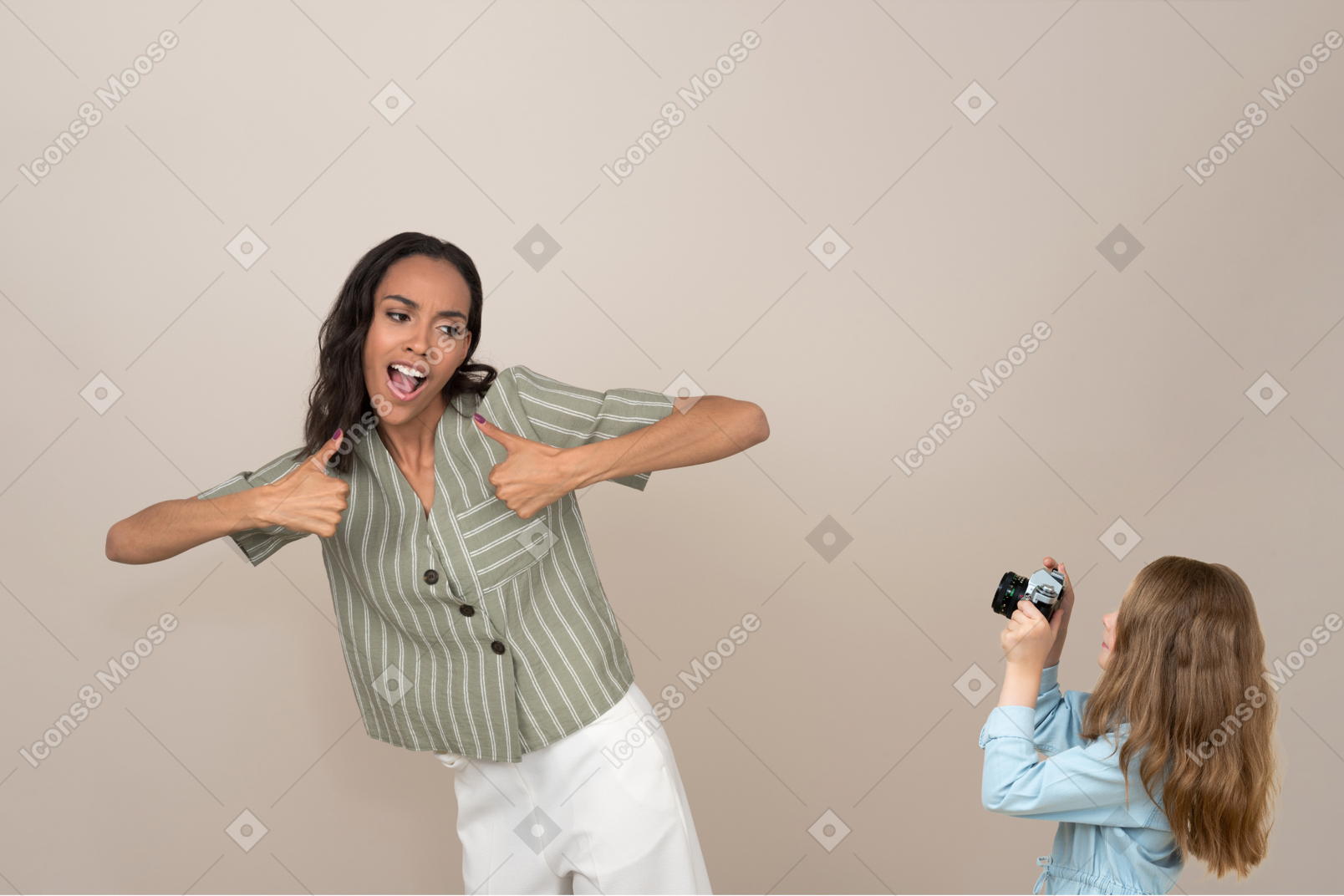 Little girl taking a picture of a young woman