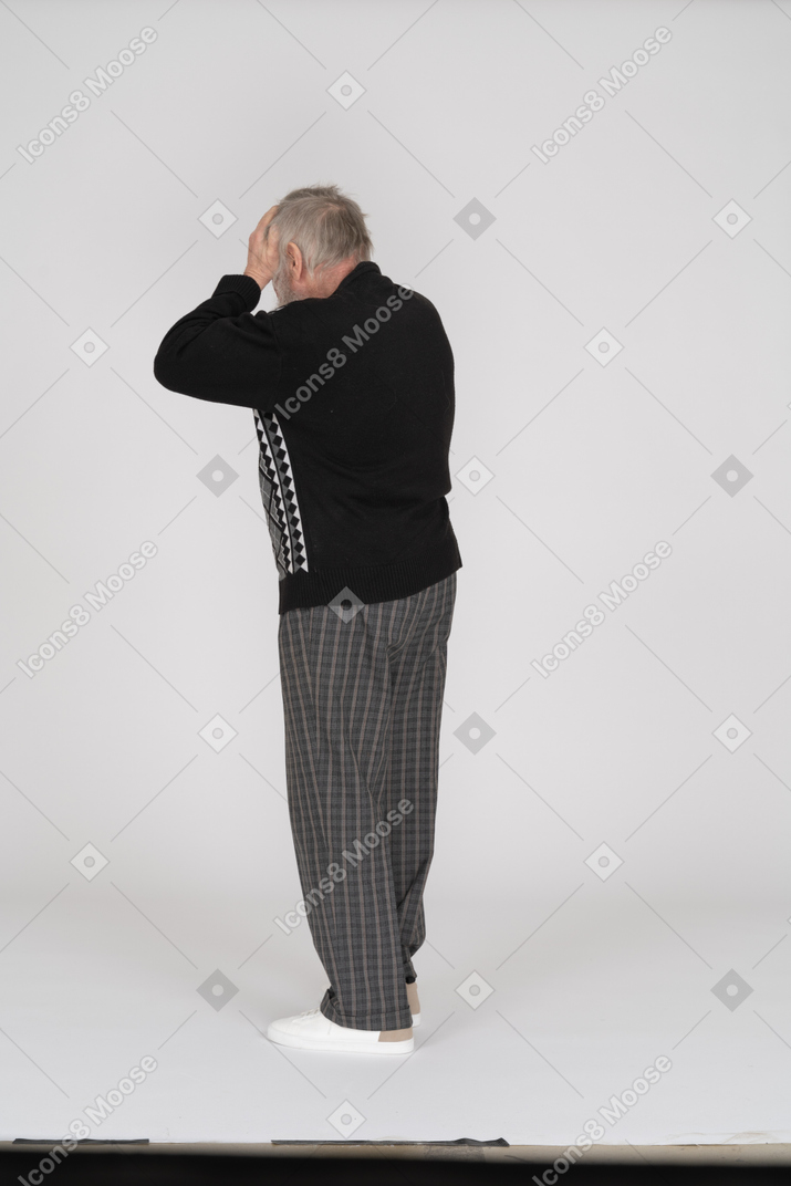 Rear view of old man with hands on head