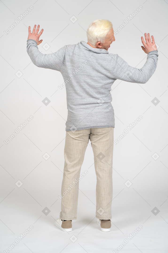 Rear view of man standing with hands up