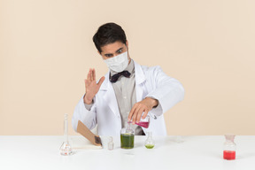 Homme scientifique assis à la table et regardant la table