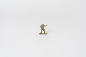 Um soldado de brinquedo em miniatura no meio da imagem contra um fundo branco liso