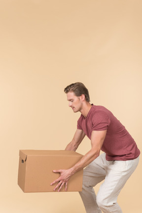 Delivery guy standing in profile and putting a parcel down