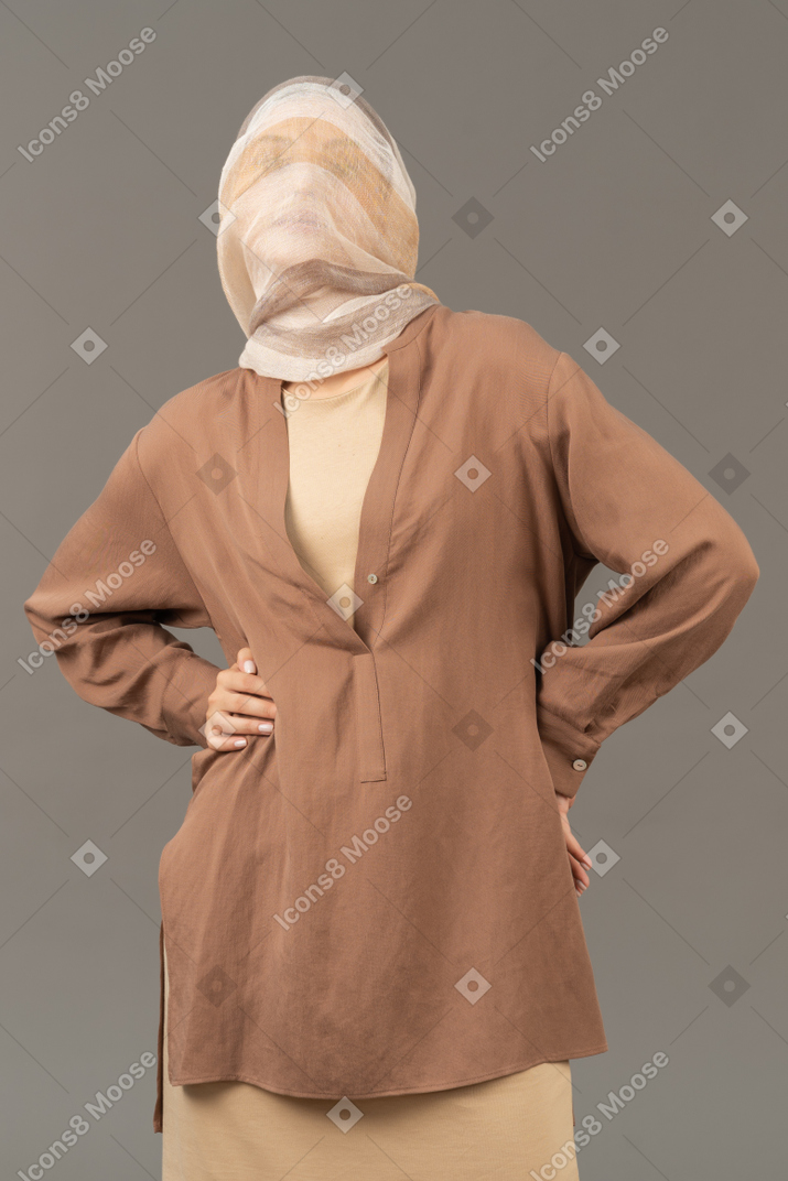 Молодая женщина в бежевой одежде, завернутая в полосатую шаль