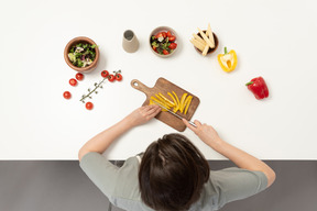 A young woman cutting bell pepper