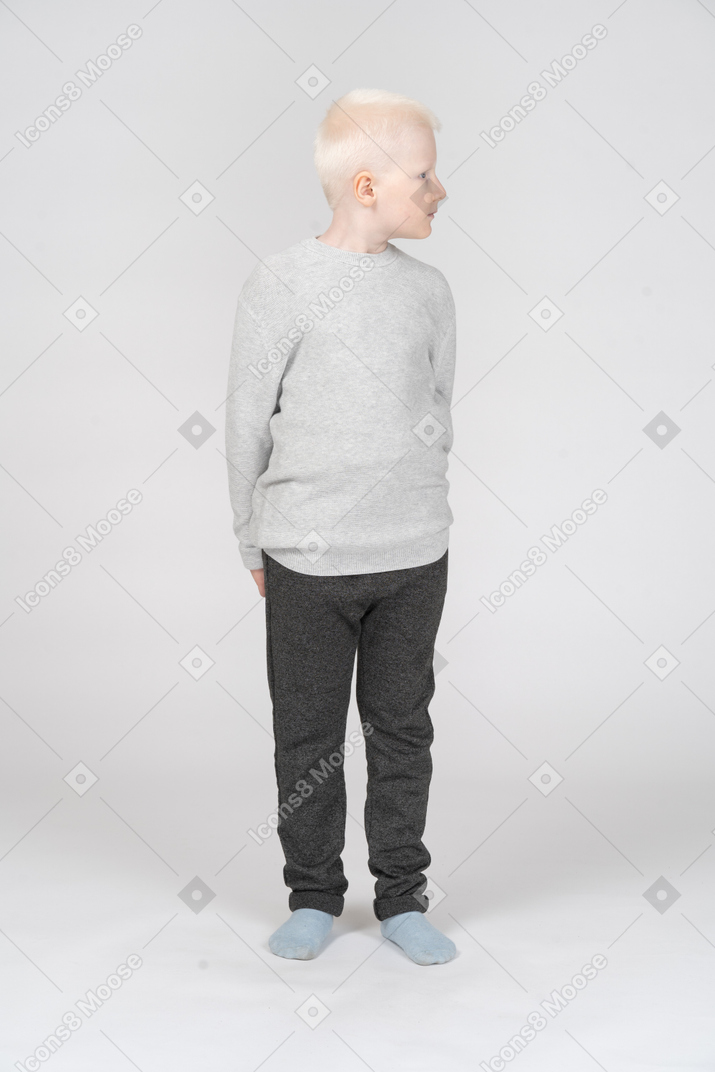 Front view of a blonde little boy looking sideways