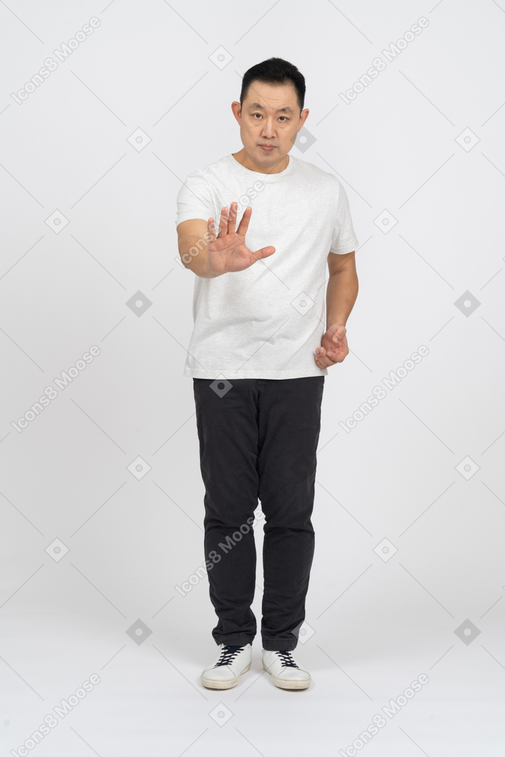 Vista frontal de un hombre con ropa informal haciendo un gesto de alto