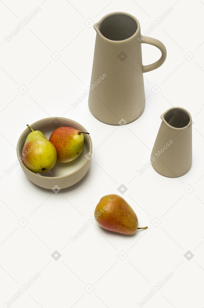 Bowl with pears and some grey jars on a white background