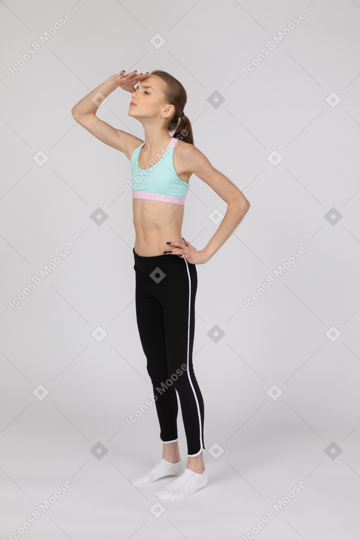 Девушка-подросток в спортивной одежде смотрит вдаль