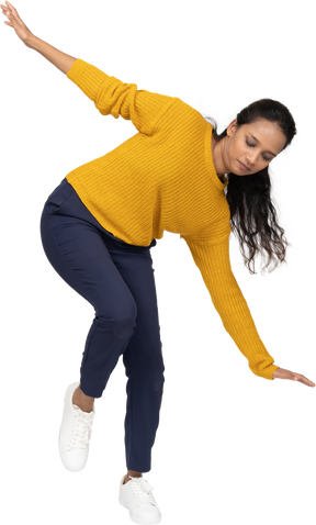 Front view of a girl in casual clothes posing on one leg with outstretched arms