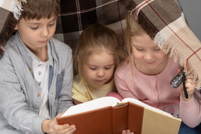 Niños leyendo un libro en una choza