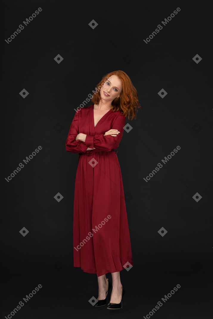 Smiling young lady in red with arms crossed