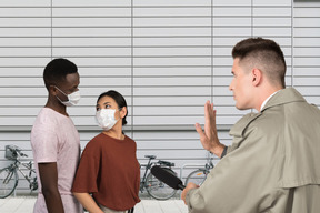 Journaliste interviewant un couple portant des masques médicaux