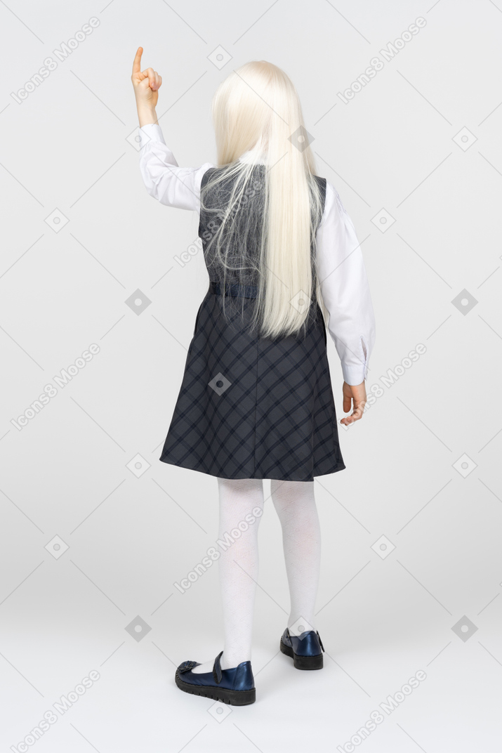 Back view of a schoolgirl pointing upwards