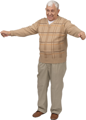 Vista frontale di un vecchio felice in abiti casual in piedi con le braccia tese