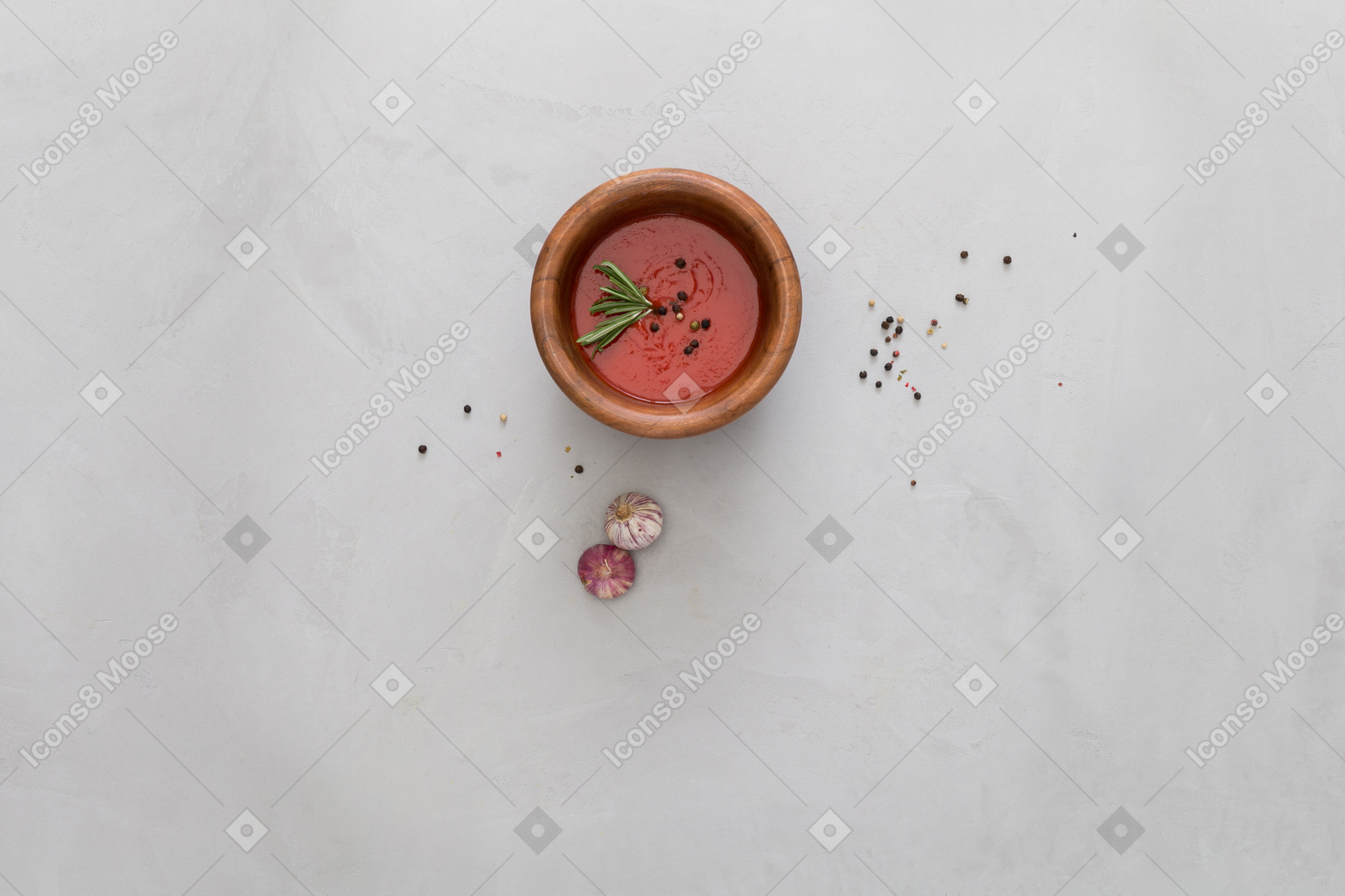 A bowl of gazpacho and some garlic