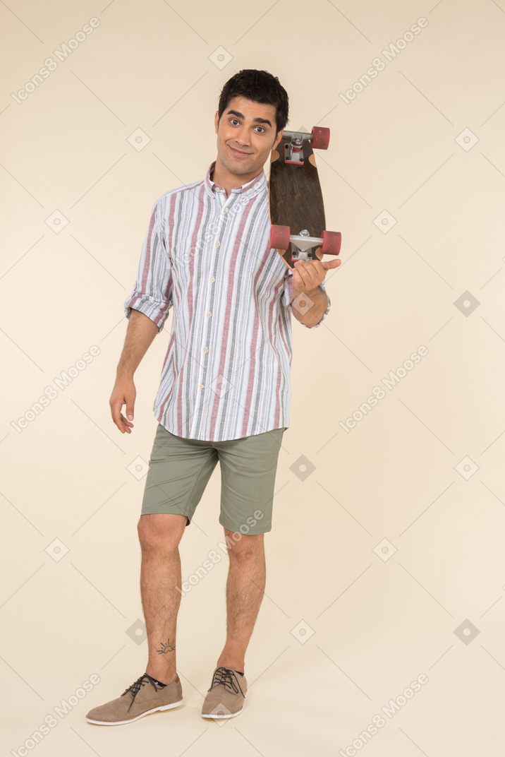 Surprised young caucasian guy holding skate