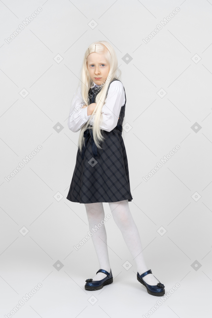 Schoolgirl looking upset with her arms crossed