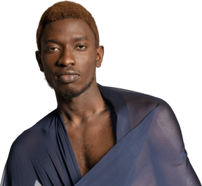 Vista frontale di un giovane uomo afro con uno scialle sulle spalle che guarda l'obbiettivo