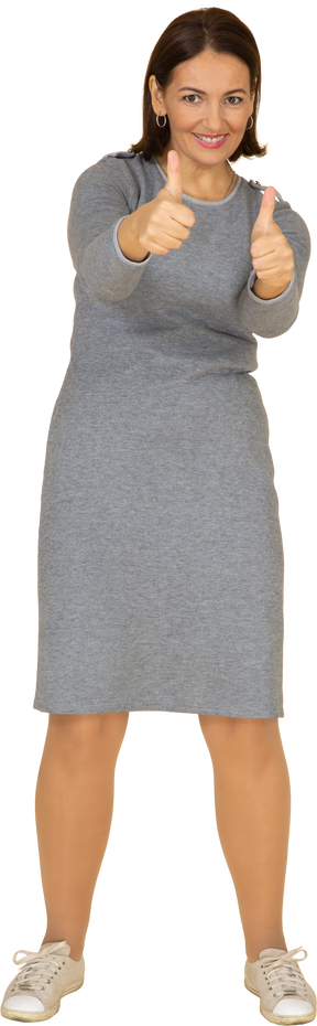 Vue de face d'une femme en robe grise montrant les pouces vers le haut