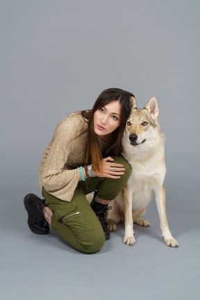 Comprimento total de uma dona sentada ao lado de seu cachorro