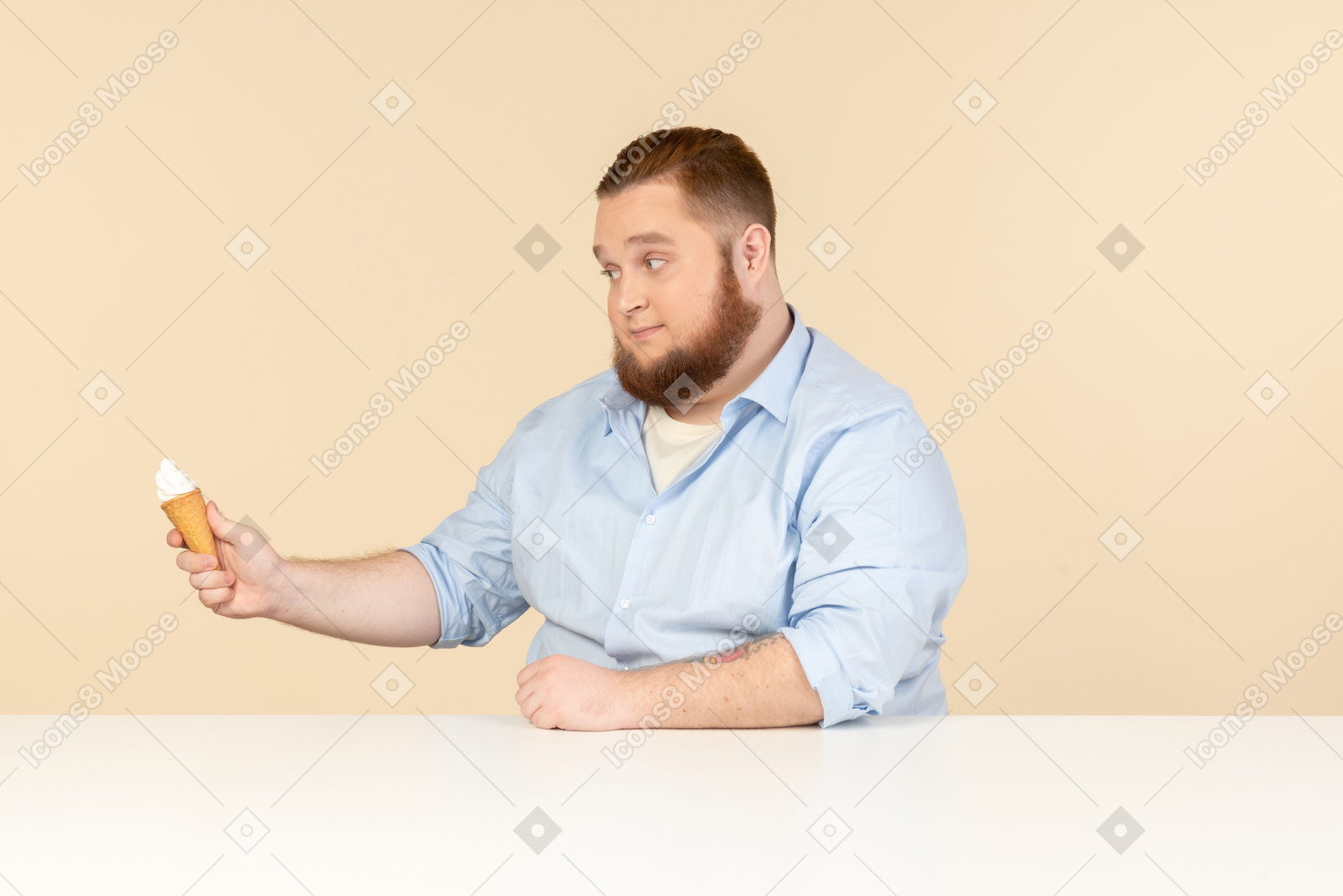 大男人坐在桌前，拿着冰淇淋