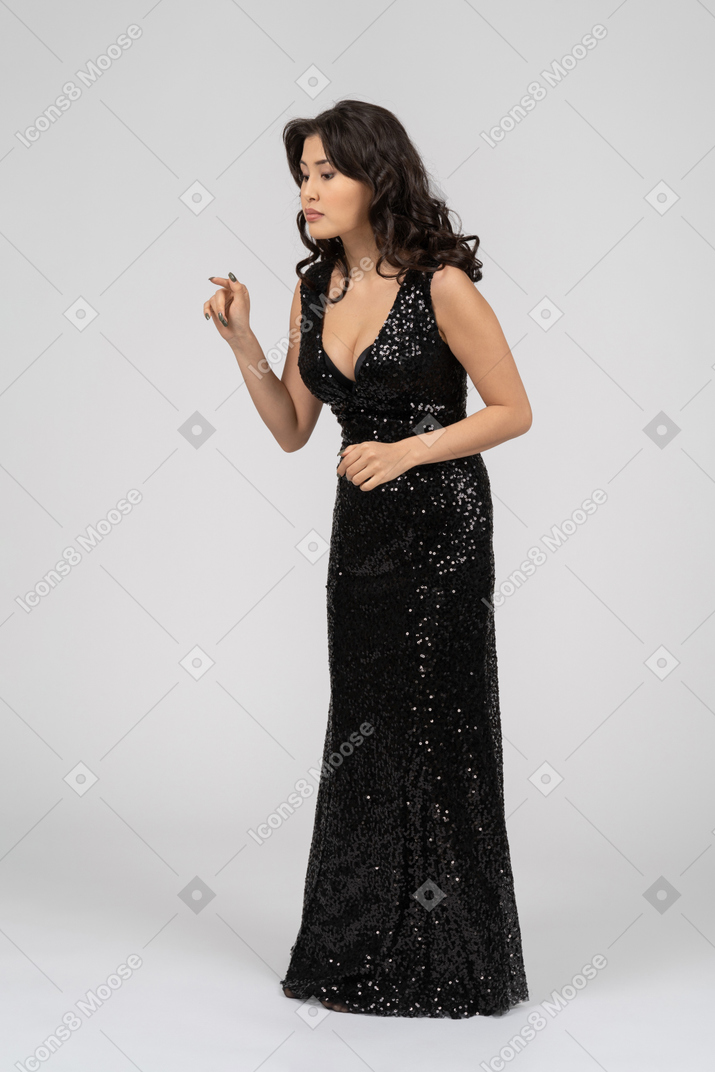 Beautiful woman in black evening dress pushing invisible button